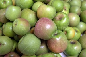 A heaping stack of freshly picked Granny Smith green apples awaits processing